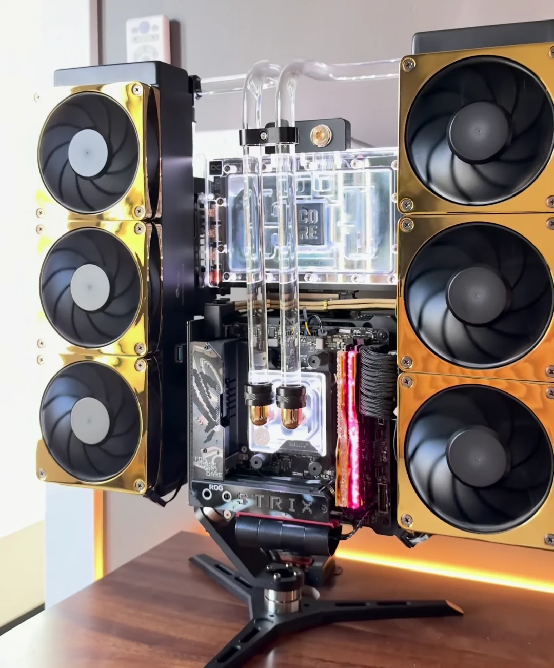 The black and gold 5090 custom PC with its twin fan arrays, clear tubing, and open-frame stand
